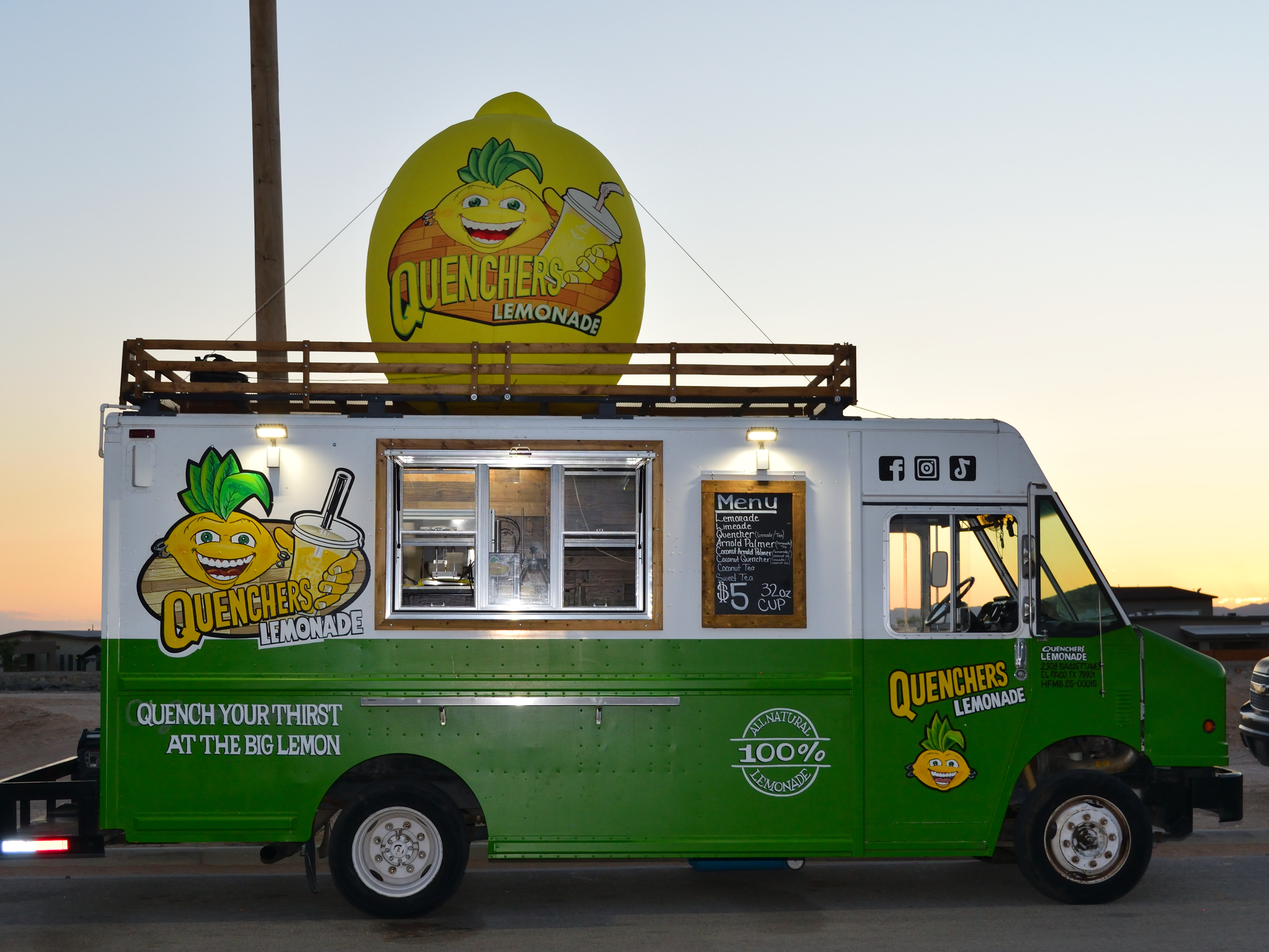 A bright and colorful food truck named 'Big Lemon' serving lemonade, featuring a large lemon logo on top and a menu displayed on the side.